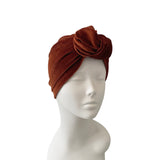Brown velvet turban on a mannequin head against a white background