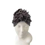 Gray velvet turban on a mannequin head against a white background