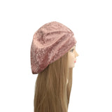 Mannequin head wearing a pink velvet beret on a white background