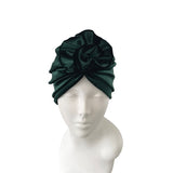 Dark green headscarf with floral design on a mannequin head against a white background