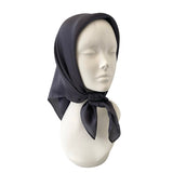 Mannequin head wearing a dark gray scarf on a white background