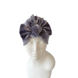Gray velvet headband on a mannequin head against a white background