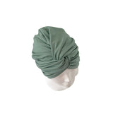 Green headscarf on a mannequin head against a white background