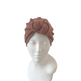 Brown knit turban on a mannequin head against a white background
