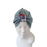 Gray headscarf with a floral pattern on a mannequin head against a white background