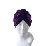 Purple turban on a mannequin head against a white background