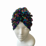 Multicolored sequin turban on a mannequin head against a white background