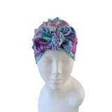 Colorful patterned headscarf on a mannequin head against a white background