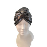 A metallic, shimmery dark brown or bronze headwrap turban hat displayed on a white mannequin head against a plain white background.