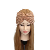 Mannequin head with long brown hair wearing a beige lace headband on a white background