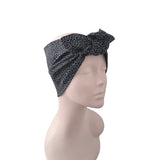A black and gray leopard print knotted headwrap displayed on a beige mannequin head against a plain white background.
