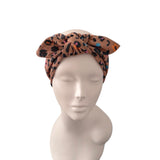 A leopard print fabric headwrap styled on a mannequin head against a plain white background.