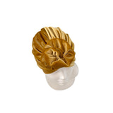Gold velvet turban on a mannequin head against a white background