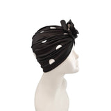 Black headscarf with cut-out design and bow on a mannequin head against a white background