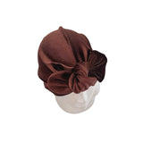 Brown turban on a mannequin head against a white background