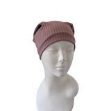 Pink knit beanie on a mannequin head against a white background