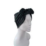 A black and dark green striped fabric headwrap turban with a large bow on top, displayed on a white mannequin head against a plain white background.