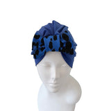 Blue headscarf with black patterns on a mannequin head against a white background
