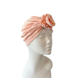 Pink towel turban on a mannequin head against a white background