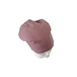 Pink ribbed knit beanie on a mannequin head against a white background
