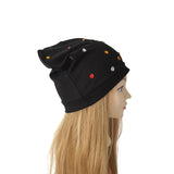A black slouchy beanie hat with small colorful sequins, displayed on a mannequin head with long blonde hair against a plain white background.