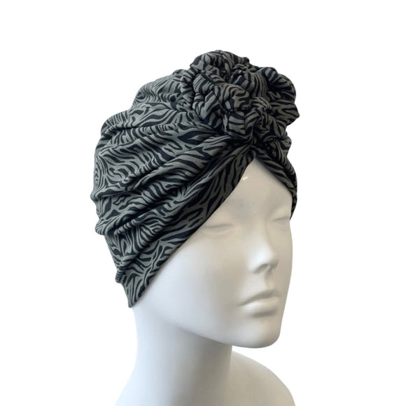 Gray patterned headscarf on a mannequin head against a white background