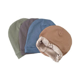 Four beanies in different colors arranged on a white background