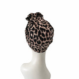 Leopard print headscarf on a mannequin head against a white background