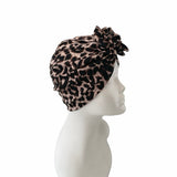 Leopard print headscarf on a mannequin head against a white background