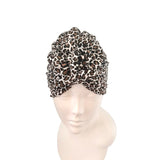 Leopard print turban on a mannequin head against a white background
