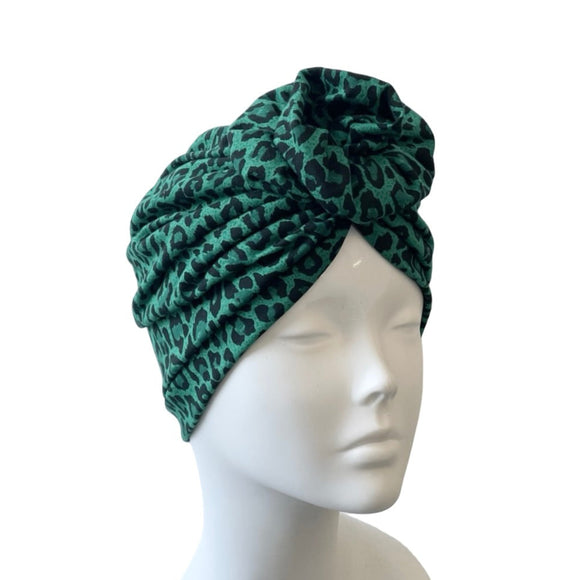 Green patterned headscarf on a mannequin head against a white background
