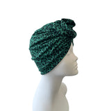 Green leopard print headscarf on a mannequin head against a white background