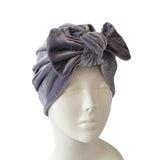 Gray turban with a bow on a mannequin head against a white background