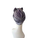 Gray velvet turban on a mannequin head against a white background