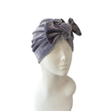 Gray velvet headband on a mannequin head against a white background