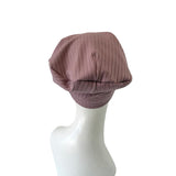 Purple ribbed turban on a mannequin head against a white background