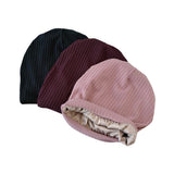 Three ribbed knit hats in black, brown, and pink on a white background