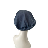 Blue textured headscarf on a mannequin head against a white background