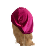Magenta headscarf on a mannequin head with blonde hair against a white background