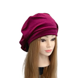 Purple headscarf on a mannequin head with long hair against a white background