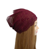 Maroon beanie with lace details on a mannequin head against a white background