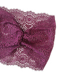 Close-up of a purple lace fabric with intricate patterns on a white background