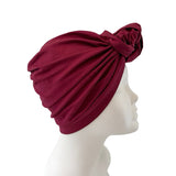 Red headscarf with a knot on a mannequin head against a white background