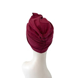 Maroon headscarf on a mannequin head against a white background