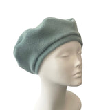 Green beret on a mannequin head against a white background