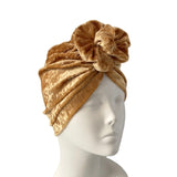 Gold turban on a mannequin head against a white background