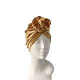 Gold headscarf on a mannequin head against a white background