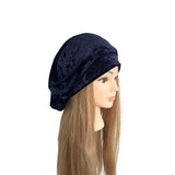 Navy blue velvet headscarf on a mannequin head with long brown hair against a white background