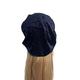 Black velvet bonnet on a mannequin head with blonde hair against a white background