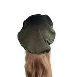 Green beret on a mannequin head with blonde hair against a white background